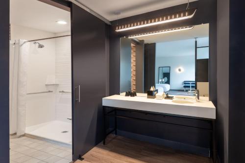 a bathroom with a sink and a mirror at Aloft Austin South in Austin