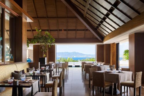 a restaurant with tables and chairs and a view of the ocean at The Ritz-Carlton Okinawa in Nago