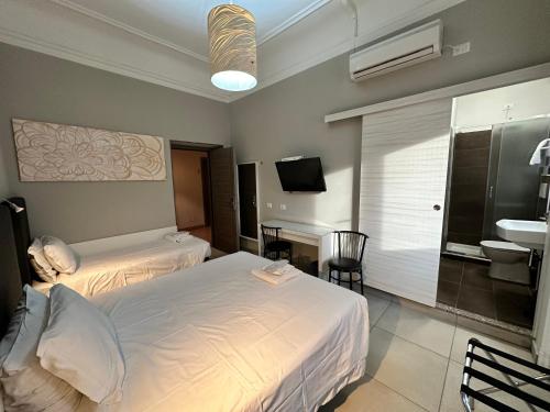 a hotel room with two beds and a bathroom at Hotel Bogart Milano in Milan