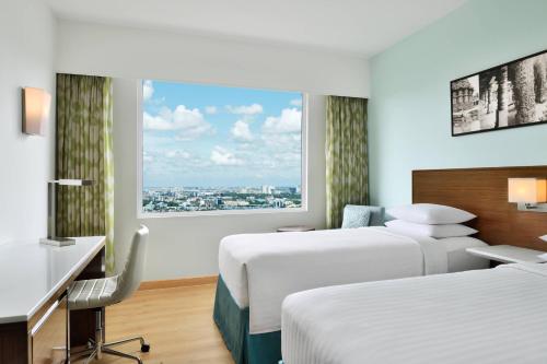 a hotel room with two beds and a window at Fairfield by Marriott Bengaluru Rajajinagar in Bangalore