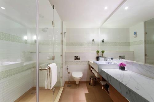 a bathroom with two sinks and a shower and a toilet at Fairfield by Marriott Bengaluru Rajajinagar in Bengaluru