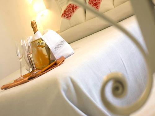 a bottle of champagne on a tray on a bed at Albergo Diffuso Mannois in Orosei
