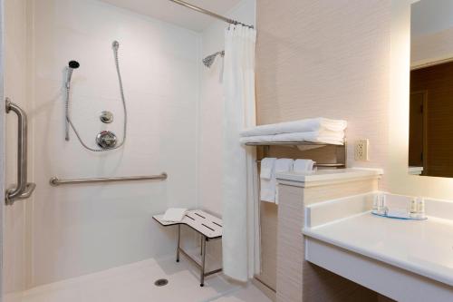 La salle de bains blanche est pourvue d'une douche et d'un lavabo. dans l'établissement Fairfield Inn & Suites by Marriott Medina, à Medina