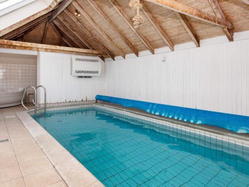a large swimming pool with blue water in a building at 12 person holiday home in Hvide Sande in Havrvig