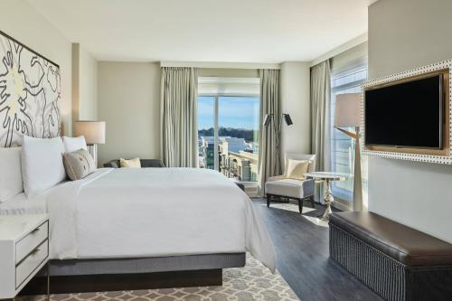 a hotel room with a large bed and a television at The Hotel at Avalon, Autograph Collection in Alpharetta