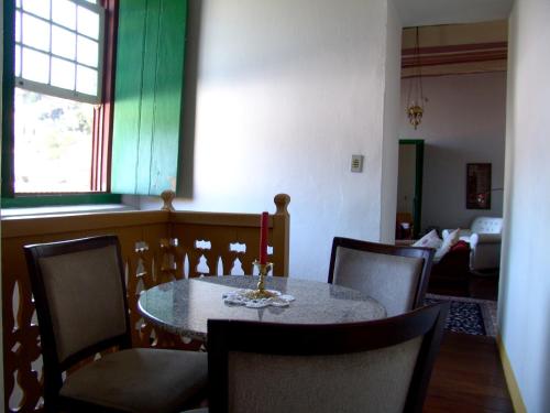 a dining room with a table and chairs and a living room at Casa de João in Ouro Preto