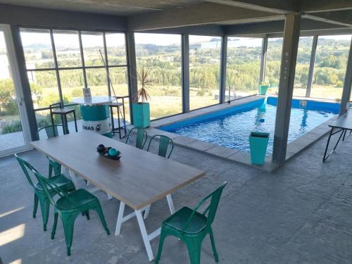 - une table et des chaises en face de la piscine dans l'établissement La Casa de los Vientos, à Tandil
