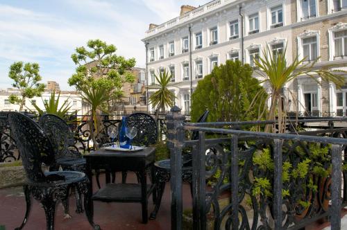 a balcony with chairs and a table and a building at Rushmore Hotel in London