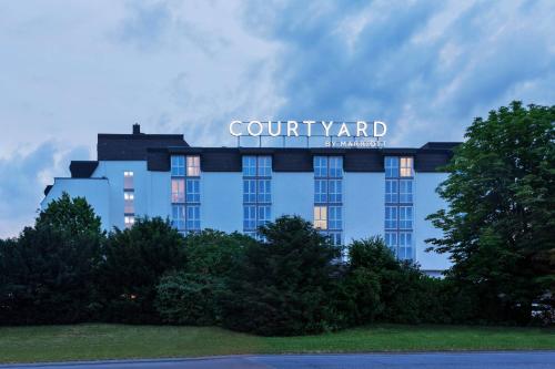 Un bâtiment bleu avec un panneau en haut dans l'établissement Courtyard by Marriott Wiesbaden-Nordenstadt, à Wiesbaden