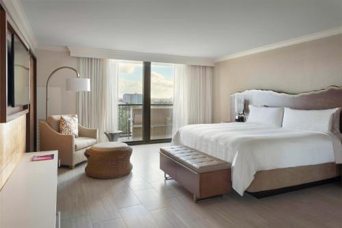 um quarto de hotel com uma cama grande e uma cadeira em Fort Lauderdale Marriott Harbor Beach Resort & Spa em Fort Lauderdale