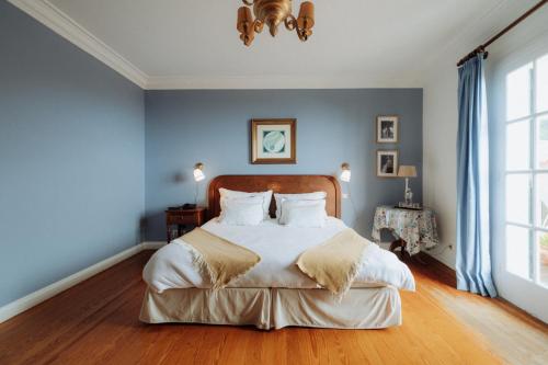 a bedroom with a large bed with blue walls at Villa Alto Boutique Hotel in Ponta do Sol