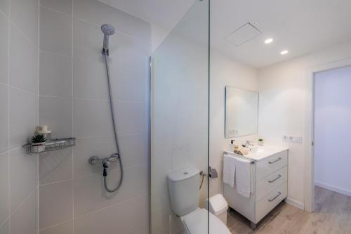 La salle de bains est pourvue d'une douche, de toilettes et d'un lavabo. dans l'établissement White suites 2, à Cala d´Or