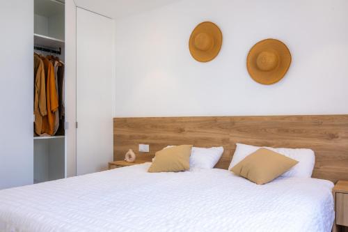 - une chambre avec un grand lit blanc et 2 oreillers dans l'établissement White suites 2, à Cala d´Or