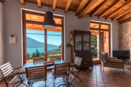 a dining room with a table and chairs and a large window at Villa Limone in Limone sul Garda
