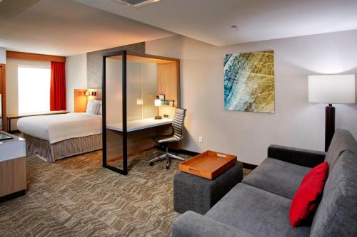 a hotel room with a couch and a bed at SpringHill Suites by Marriott Dayton Beavercreek in New Germany