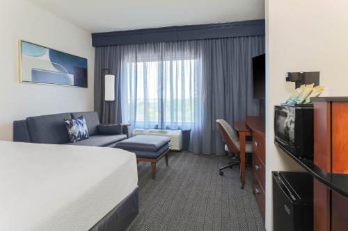 a hotel room with a bed and a living room at Courtyard Austin Airport in Austin