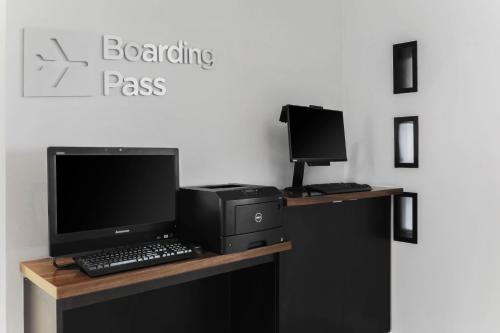 a desk with a computer and a monitor and keyboard at Courtyard Austin Airport in Austin