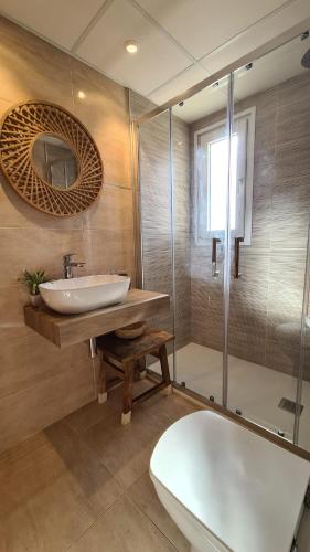 a bathroom with a sink and a mirror and a tub at Oliva Moon in Oliva