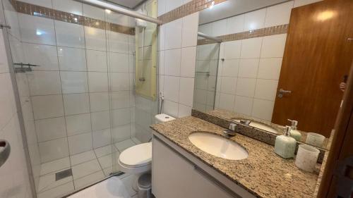 a bathroom with a sink and a toilet and a mirror at Refúgio Beira Lago- Life Resort in Brasilia