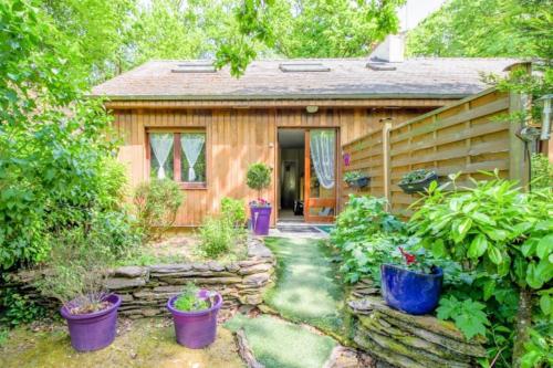 une petite maison en bois avec des plantes devant elle dans l'établissement Gite des landes de la houssais, à Guichen
