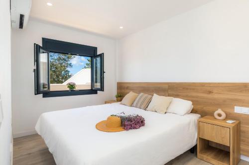 a bedroom with a large white bed with a mirror at White suites 3 in Cala d´Or