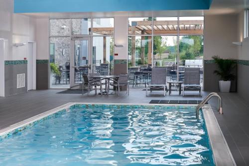 a swimming pool with a table and chairs at TownePlace Suites by Marriott Cleveland Solon in Solon