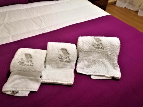 a pair of white towels on a bed at Casa de Maçaneira in Miranda do Douro