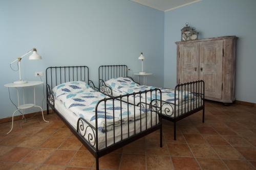 two beds in a room with two tables and a cabinet at Villa Limone in Limone sul Garda