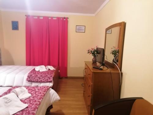 a bedroom with two beds and a mirror and a dresser at Casa de Maçaneira in Miranda do Douro
