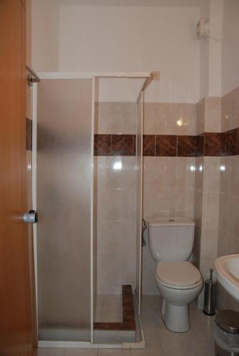 a bathroom with a toilet and a glass shower stall at Monemvasia Hotel in Skala Sotiros