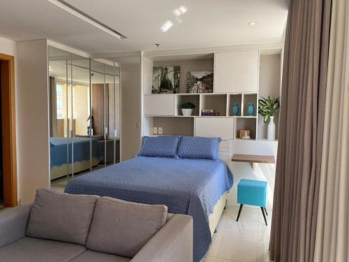 ein Schlafzimmer mit einem Bett und einem Sofa in der Unterkunft Incrível Apto DF Plaza com vista in Brasilia