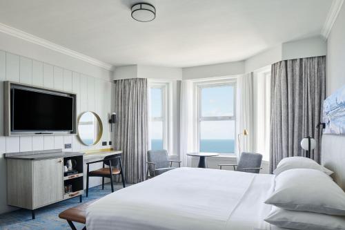ボーンマスにあるボーンマス ハイクリフ マリオット ホテルのベッドとテレビが備わるホテルルームです。