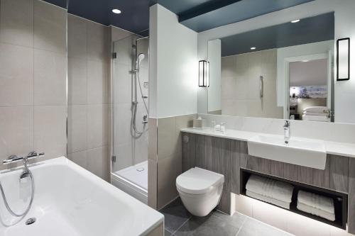 a bathroom with a sink and a toilet and a tub at Bournemouth Highcliff Marriott Hotel in Bournemouth