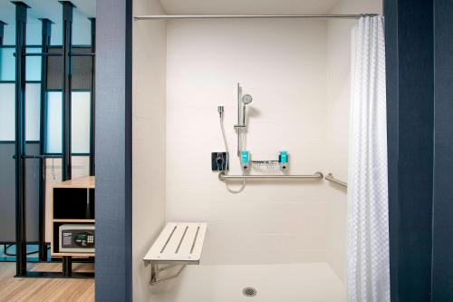 a bathroom with a bench and a shower at Aloft Dallas DFW Airport Grapevine in Coppell