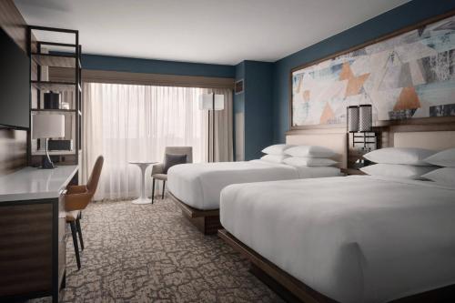 a hotel room with two beds and a desk at Marriott Boston Quincy in Quincy