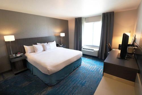 a hotel room with a bed and a television at Fairfield Inn & Suites Des Moines Airport in Des Moines