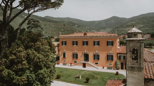 a large peach colored building with a tower at Agriturismo Villa Rosselmini in Calci