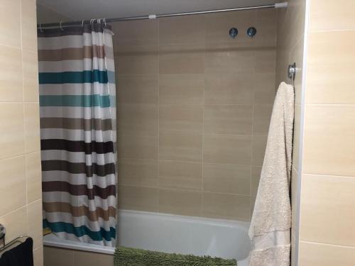 baño con cortina de ducha y bañera en FeWo - Moncofa Apartment en Moncófar
