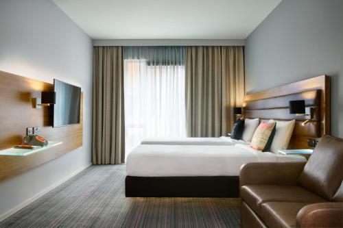 Habitación de hotel con cama y sofá en Moxy Dublin City en Dublín