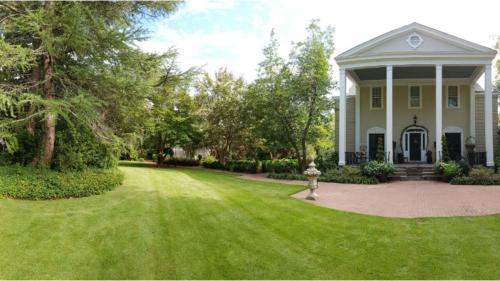 una casa blanca con un patio con una boca de incendios en Clevedale Historic Inn and Gardens, en Spartanburg