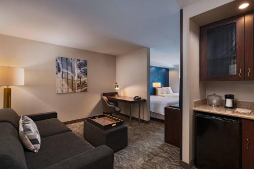 uma sala de estar com um sofá e um quarto com uma cama em SpringHill Suites Boise West/Eagle em Boise