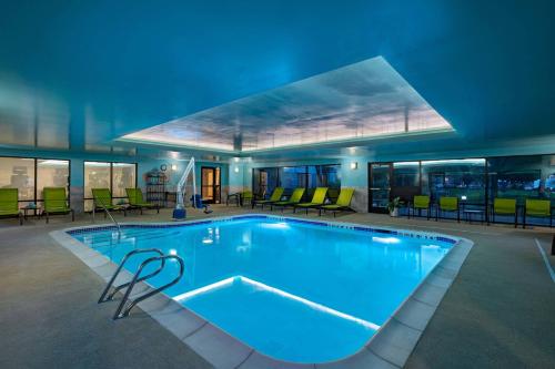 a large swimming pool with blue lighting in a building at SpringHill Suites Boise West/Eagle in Boise