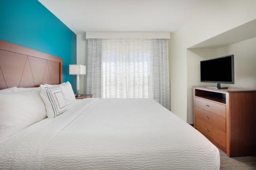 a bedroom with a large bed and a flat screen tv at Residence Inn Midland in Midland