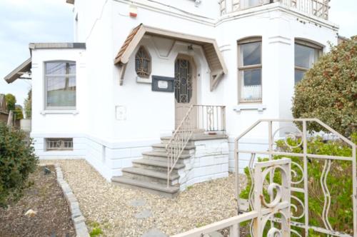uma casa branca com escadas em frente em Gîte de charme dans une maison bourgeoise em Frameries