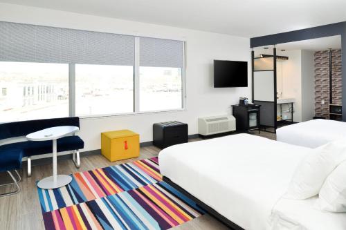 um quarto com uma cama, uma secretária e uma televisão em Aloft North Kansas City em Kansas City