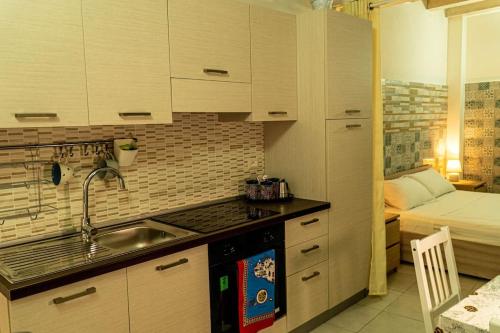 a kitchen with a sink and a bed in a room at Casa Rosa Apartments Ortgia in Siracusa