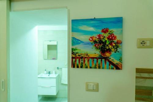 un baño con una pintura colgada en la pared en Casa Rosa Apartments Ortgia en Siracusa