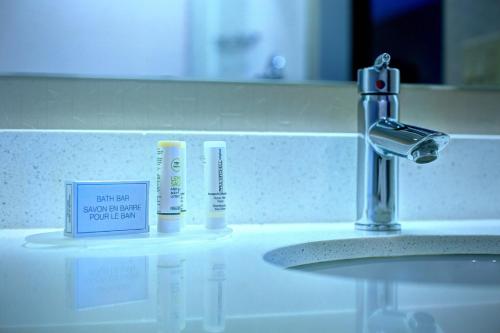 un lavabo con cepillos de dientes y una señal en él en SpringHill Suites Harrisburg Hershey, en Harrisburg