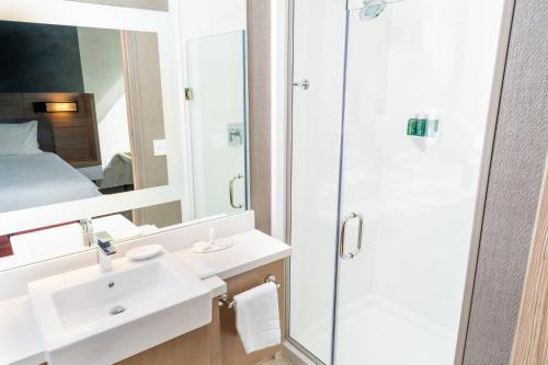 a bathroom with a shower and a sink and a mirror at SpringHill Suites by Marriott Ontario Airport/Rancho Cucamonga in Ontario
