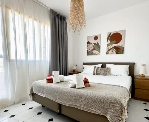 a bedroom with a bed and a large window at Albir Hills Apartments in Albir